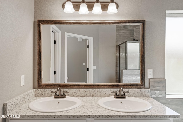 1329 Madero Ave, El Paso, TX 79928 - full bathroom featuring double vanity, a shower stall, and a textured wall