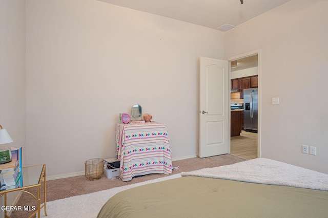 1916 William Caples St, El Paso, TX 79938 - bedroom featuring stainless steel refrigerator with ice dispenser, light colored carpet, and baseboards