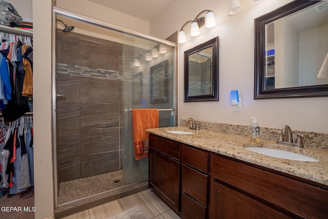 1916 William Caples St, El Paso, TX 79938 - full bath featuring a walk in closet, double vanity, and a shower stall