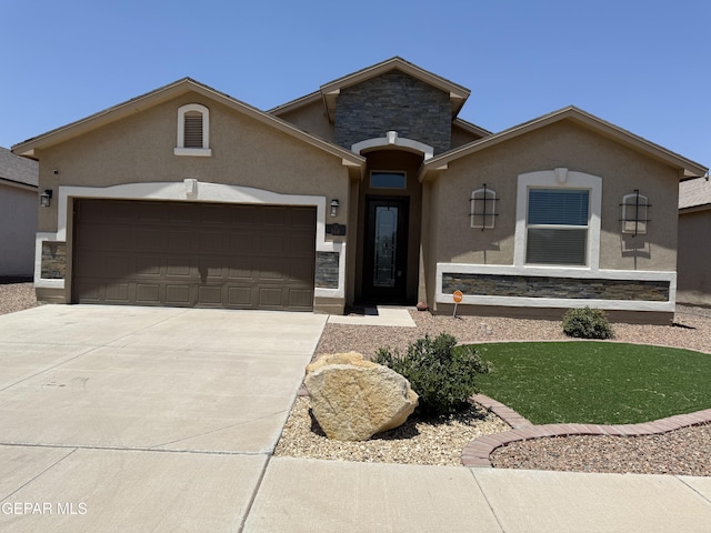 568 Issa Cir, El Paso, TX 79932 - view of front facade featuring stone siding, an attached garage, stucco siding, and driveway