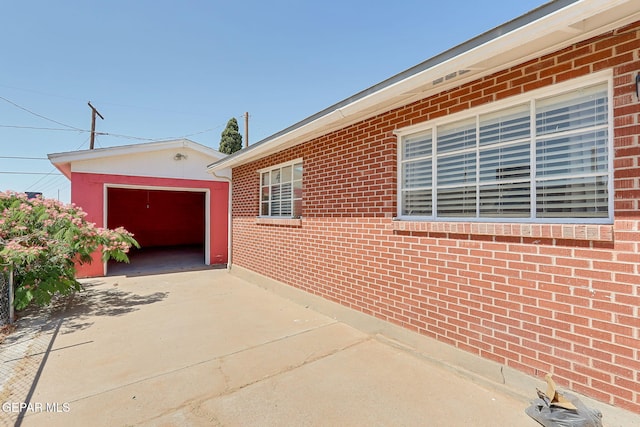 3408 Pierce Ave, El Paso, TX 79930 - view of property exterior featuring a garage, driveway, an outbuilding, and brick siding