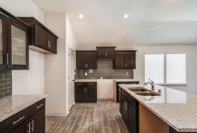 1361 Indigo Sky St, El Paso, TX 79928 - kitchen featuring a sink, decorative backsplash, dark brown cabinetry, dark wood finished floors, and light stone countertops