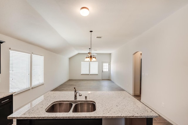 1361 Indigo Sky St, El Paso, TX 79928 - kitchen featuring a sink, hanging light fixtures, light wood-style floors, lofted ceiling, and arched walkways
