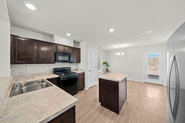 14573 Banana Yucca Ave, Horizon City, TX 79928 - kitchen featuring black appliances, a sink, a kitchen island, dark brown cabinets, and light countertops