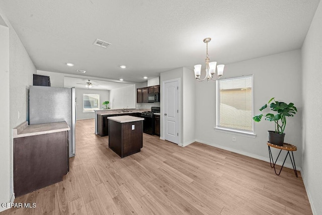 14573 Banana Yucca Ave, Horizon City, TX 79928 - kitchen featuring black appliances, a sink, a center island, light countertops, and a chandelier