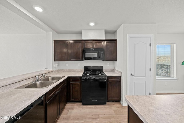 14573 Banana Yucca Ave, Horizon City, TX 79928 - kitchen featuring black appliances, a sink, light wood-style flooring, dark brown cabinetry, and light countertops