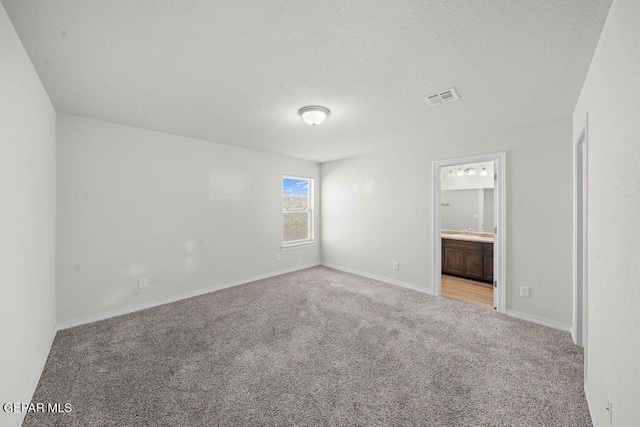 14573 Banana Yucca Ave, Horizon City, TX 79928 - unfurnished bedroom with carpet flooring, a textured ceiling, baseboards, and ensuite bath