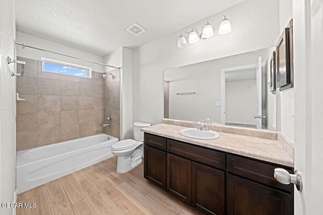 14573 Banana Yucca Ave, Horizon City, TX 79928 - full bath featuring toilet, shower / washtub combination, vanity, wood finished floors, and a textured ceiling