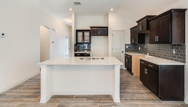13852 Summer Wave Ave, El Paso, TX 79928 - kitchen with a sink, wood finish floors, arched walkways, a kitchen island with sink, and lofted ceiling