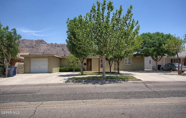 5814 Beaumont Pl, El Paso, TX 79912 - view of front of house with driveway, brick siding, a mountain view, and an attached garage