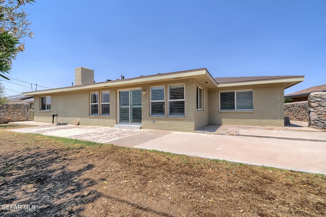 5814 Beaumont Pl, El Paso, TX 79912 - rear view of property with brick siding, a patio area, and a chimney