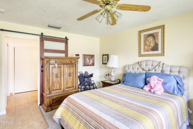 10605 Park View Cir, El Paso, TX 79935 - bedroom featuring a barn door, light tile patterned floors, and ceiling fan