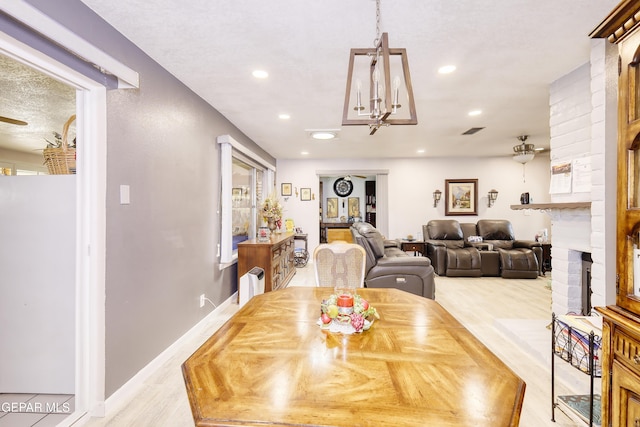 10605 Park View Cir, El Paso, TX 79935 - dining space featuring light wood-type flooring, a brick fireplace, recessed lighting, and a chandelier