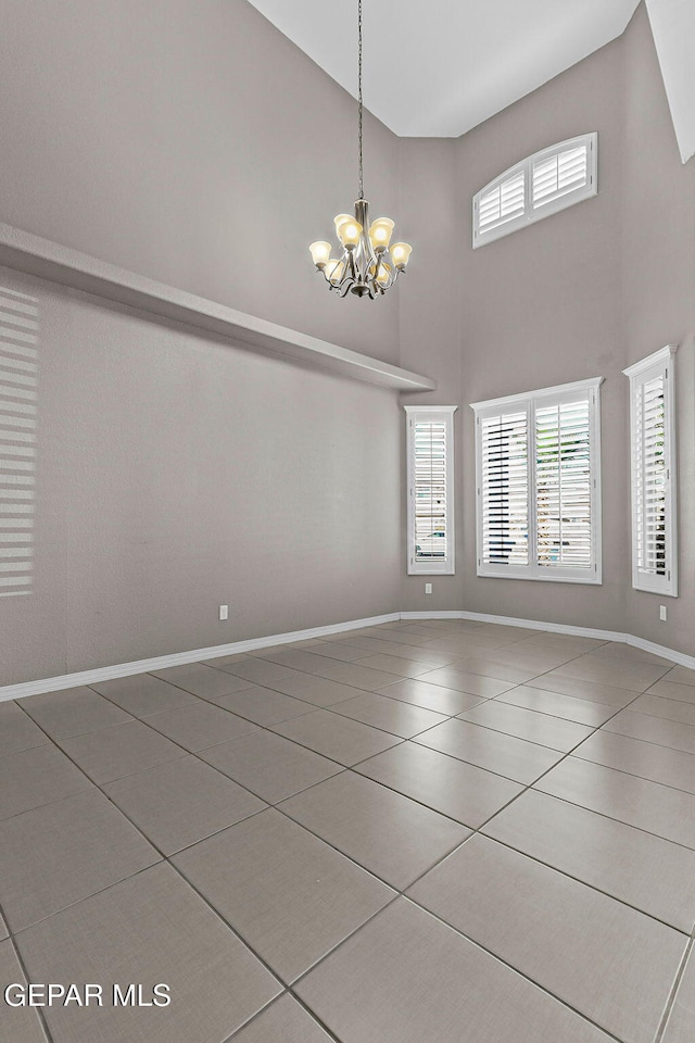 3129 Spring Willow, El Paso, TX 79938 - unfurnished room featuring tile patterned floors, a towering ceiling, a chandelier, and baseboards