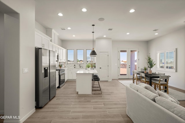 13824 Paseo Bosque Ave, El Paso, TX 79928 - kitchen with appliances with stainless steel finishes, a breakfast bar area, recessed lighting, a center island, and white cabinetry