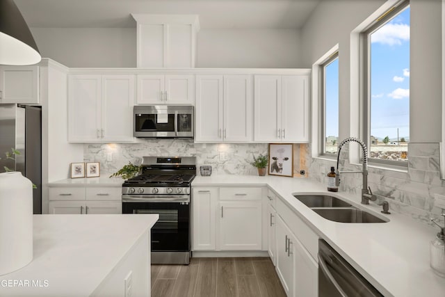 13824 Paseo Bosque Ave, El Paso, TX 79928 - kitchen featuring appliances with stainless steel finishes, a sink, white cabinets, backsplash, and light countertops