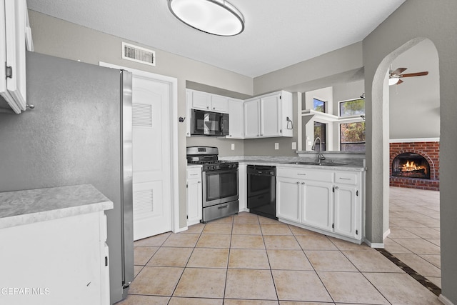 11765 Queens Garden Cir, El Paso, TX 79936 - kitchen with black appliances, light tile patterned floors, a brick fireplace, and ceiling fan