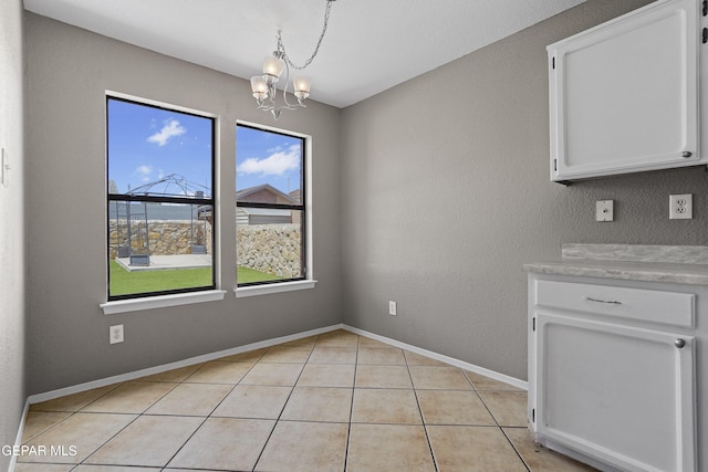 11765 Queens Garden Cir, El Paso, TX 79936 - unfurnished dining area with a chandelier and light tile patterned flooring