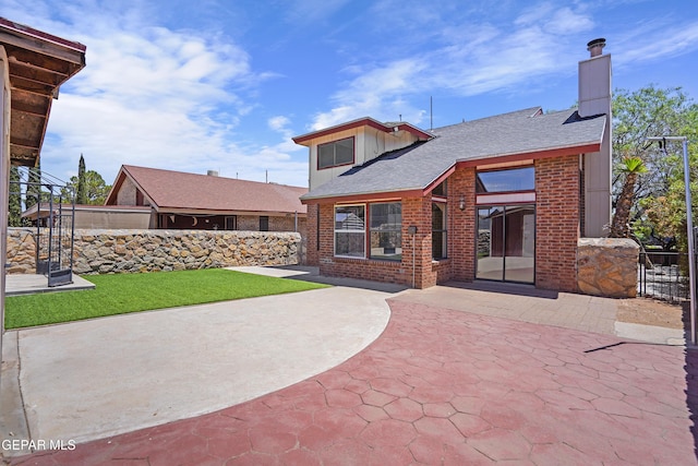 11765 Queens Garden Cir, El Paso, TX 79936 - rear view of house with a patio, brick siding, a chimney, and roof with shingles