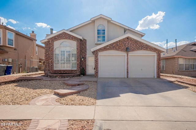 1321 Amber Morgan Dr, El Paso, TX 79936 - view of front of home with brick siding, an attached garage, driveway, and central AC unit
