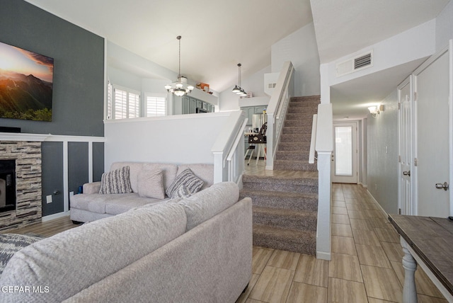 1321 Amber Morgan Dr, El Paso, TX 79936 - living room with a chandelier, stairs, a fireplace, lofted ceiling, and a decorative wall