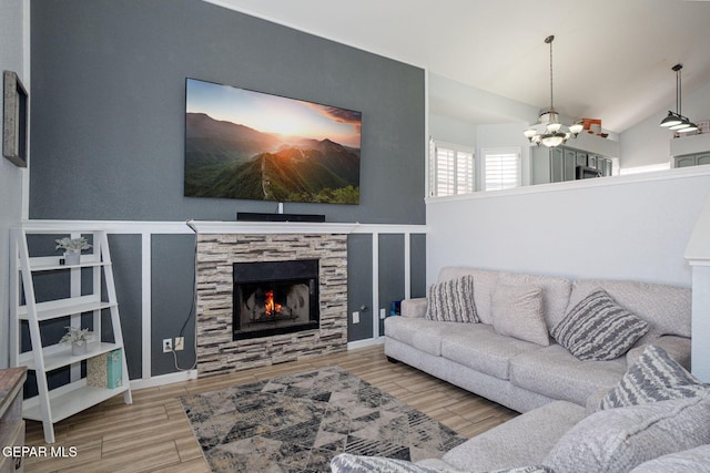1321 Amber Morgan Dr, El Paso, TX 79936 - living room with a chandelier, wood finished floors, a stone fireplace, and vaulted ceiling
