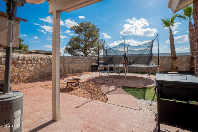 1321 Amber Morgan Dr, El Paso, TX 79936 - fenced backyard with a trampoline and a patio area