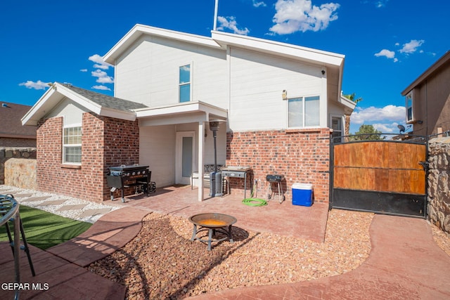 1321 Amber Morgan Dr, El Paso, TX 79936 - back of house featuring brick siding, a fire pit, a patio, and a gate