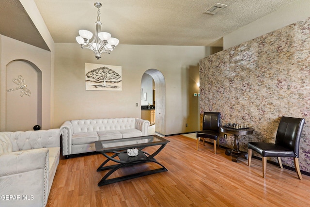 658 John Martin Ct, El Paso, TX 79932 - living room featuring arched walkways, a chandelier, and light wood finished floors
