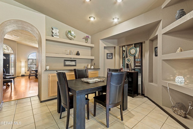 658 John Martin Ct, El Paso, TX 79932 - dining space with arched walkways, vaulted ceiling, and light tile patterned flooring