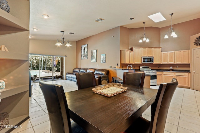 658 John Martin Ct, El Paso, TX 79932 - dining space featuring a chandelier, light tile patterned flooring, a high ceiling, and a skylight