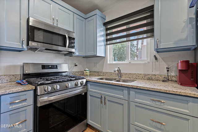 658 John Martin Ct, El Paso, TX 79932 - kitchen featuring appliances with stainless steel finishes, a sink, gray cabinetry, and light stone countertops