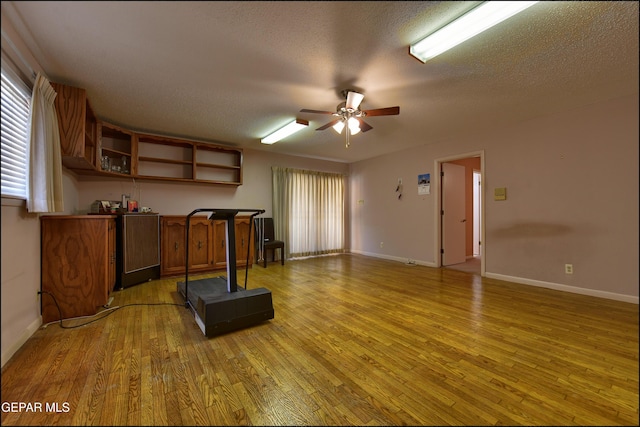 8904 Mettler Dr, El Paso, TX 79925 - kitchen featuring open shelves, light wood-style floors, ceiling fan, a textured ceiling, and brown cabinets