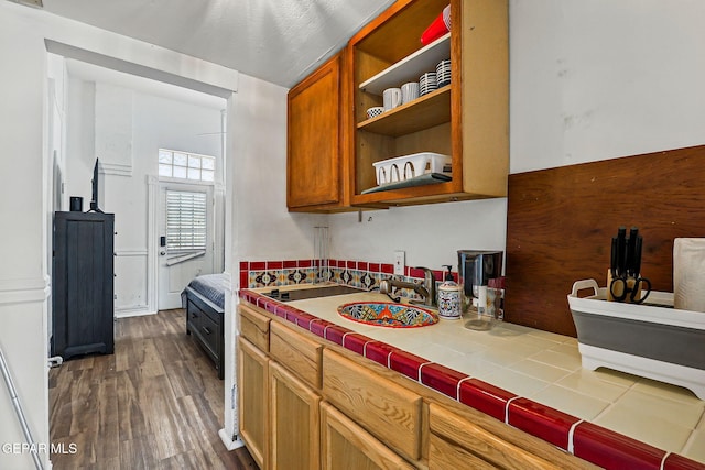 712 N Ochoa St, El Paso, TX 79902 - kitchen with tile countertops, dark wood-style floors, brown cabinetry, open shelves, and a sink