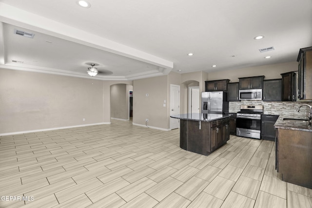 12632 Katherine Brennand Rd, El Paso, TX 79928 - kitchen with stainless steel appliances, arched walkways, open floor plan, a sink, and baseboards