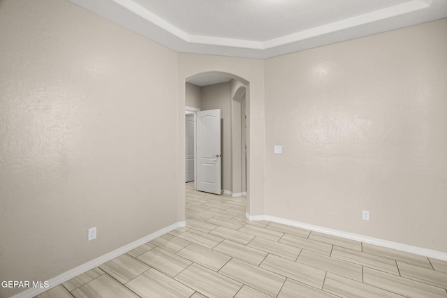 12632 Katherine Brennand Rd, El Paso, TX 79928 - spare room with arched walkways, baseboards, and a tray ceiling