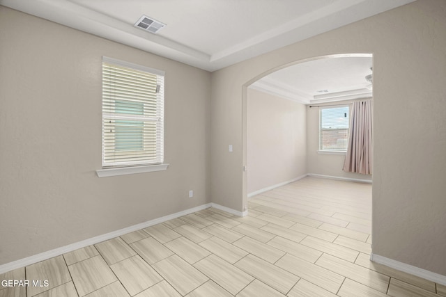 12632 Katherine Brennand Rd, El Paso, TX 79928 - spare room featuring arched walkways, a tray ceiling, and baseboards