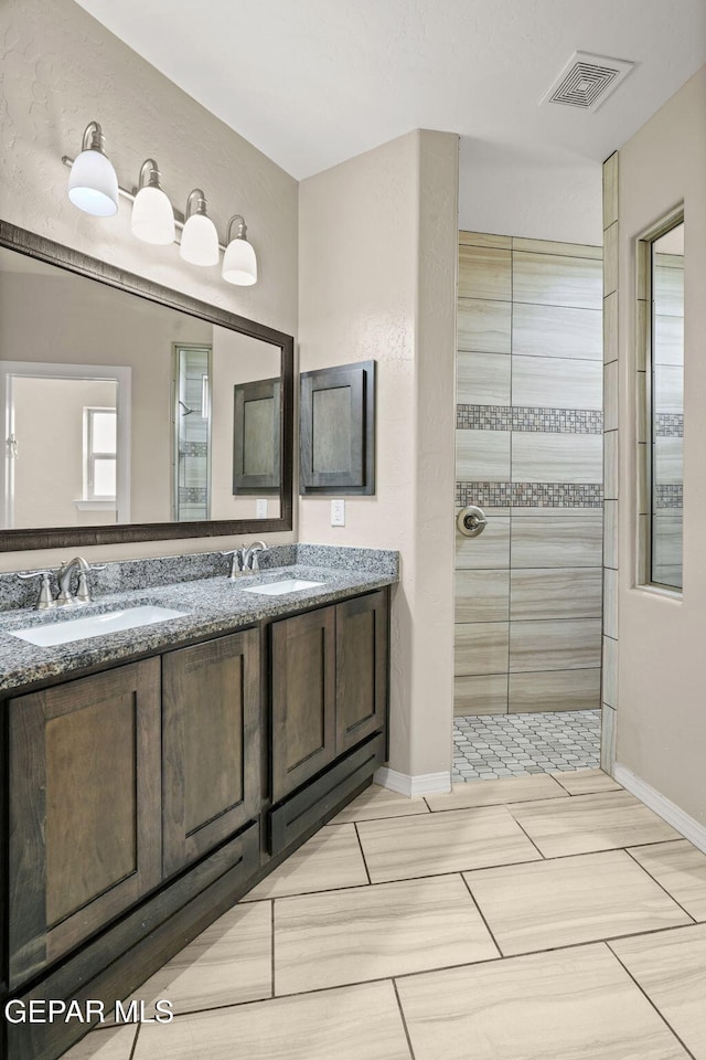 12632 Katherine Brennand Rd, El Paso, TX 79928 - bathroom featuring double vanity, walk in shower, and baseboards
