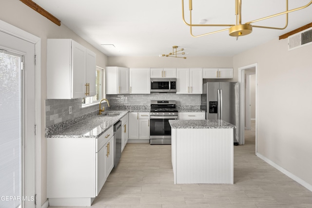 4317 Larchmont Dr, El Paso, TX 79902 - kitchen with stainless steel appliances, a sink, tasteful backsplash, a kitchen island, and light stone counters