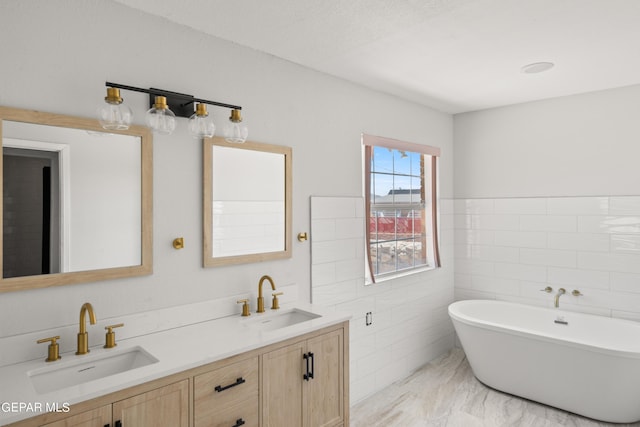 4317 Larchmont Dr, El Paso, TX 79902 - full bath with double vanity, a soaking tub, tile walls, marble finish flooring, and wainscoting