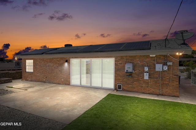 4317 Larchmont Dr, El Paso, TX 79902 - back of property featuring brick siding, a patio, and roof mounted solar panels