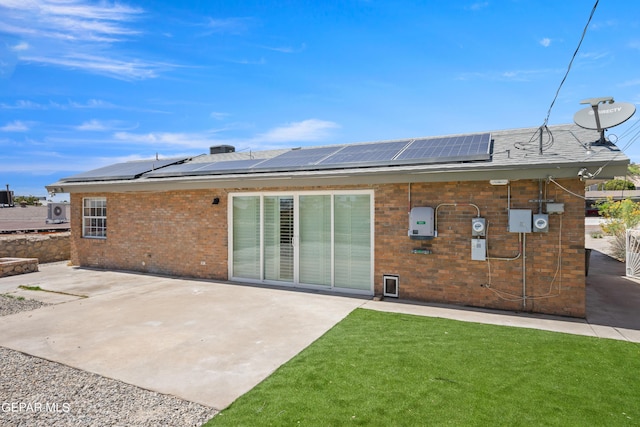 4317 Larchmont Dr, El Paso, TX 79902 - rear view of house with brick siding, a patio, solar panels, and a yard