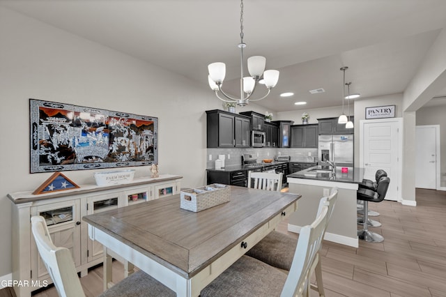 2401 Mike Price Dr, El Paso, TX 79938 - dining area featuring a chandelier, wood tiled floors, baseboards, and recessed lighting