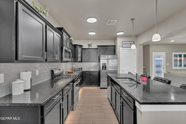 2401 Mike Price Dr, El Paso, TX 79938 - kitchen featuring appliances with stainless steel finishes, a sink, tasteful backsplash, a kitchen island with sink, and open floor plan