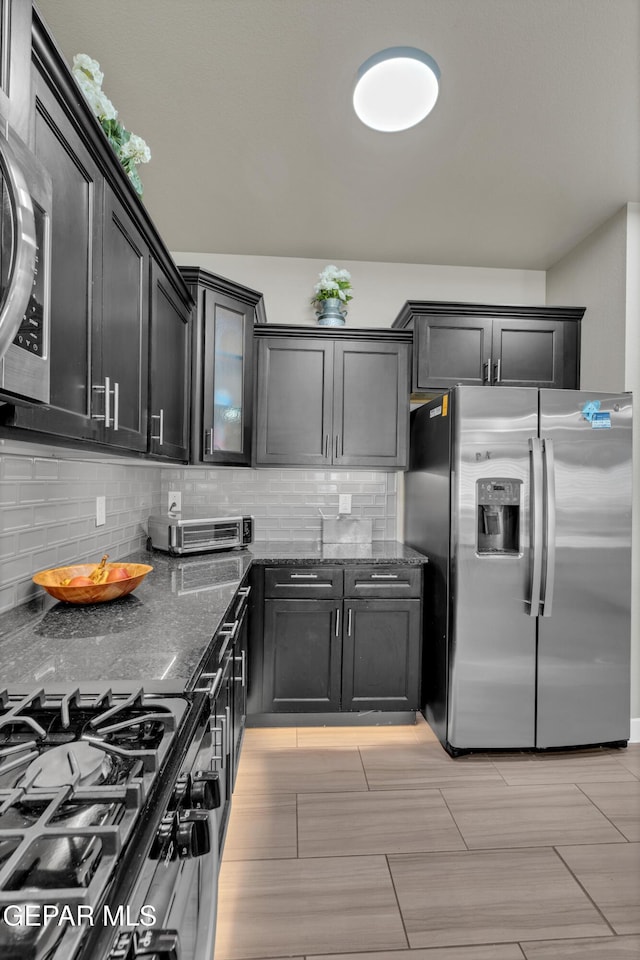 2401 Mike Price Dr, El Paso, TX 79938 - kitchen with stainless steel fridge with ice dispenser, dark stone counters, backsplash, gas stove, and dark cabinetry