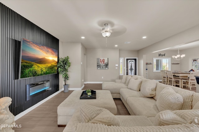 2401 Mike Price Dr, El Paso, TX 79938 - living area featuring wood finished floors, a glass covered fireplace, recessed lighting, a chandelier, and a ceiling fan