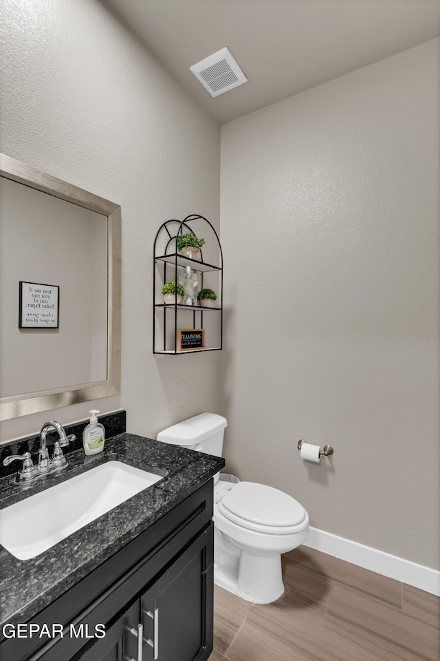2401 Mike Price Dr, El Paso, TX 79938 - half bathroom with vanity, toilet, baseboards, and wood finished floors