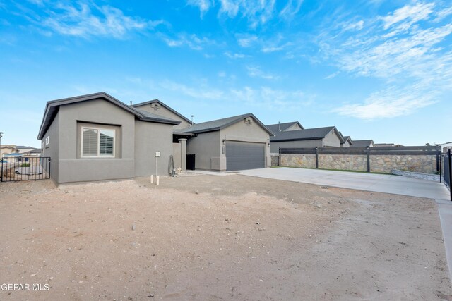 2401 Mike Price Dr, El Paso, TX 79938 - ranch-style house featuring stucco siding, an attached garage, and driveway