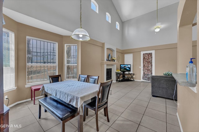 444 Ghost Flower St, Horizon City, TX 79928 - dining area featuring a glass covered fireplace, light tile patterned floors, and high vaulted ceiling