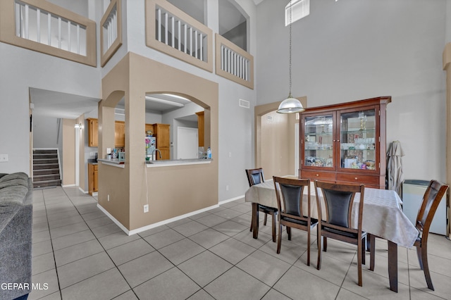 444 Ghost Flower St, Horizon City, TX 79928 - dining room with a high ceiling, light tile patterned flooring, stairway, and arched walkways